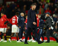 download Michael Carrick under fire, walking off the pitch looking dejected with Manchester United players in the background.