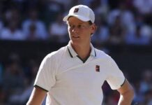 Jannik Sinner wearing a white cap and polo shirt during a tennis match
